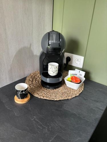 a coffee maker sitting on a counter with two cups at La cabane de Lulu in Jalhay