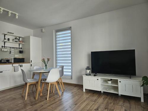 a living room with a table and a flat screen tv at Apartament Cuma - zacumuj w Pucku in Puck