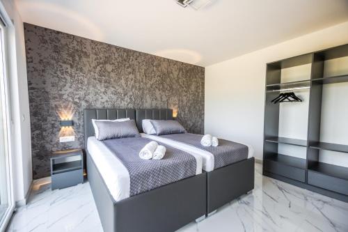 a bedroom with a king sized bed and a wall at BRAND NEW! Villa Adriatic Bay2 with a private pool in Novalja