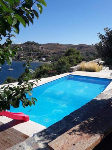 a blue swimming pool with a view of the water at House garden in Ioulis