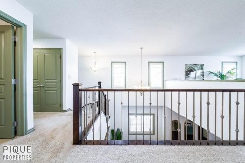 eine Treppe in einem Haus mit grüner Tür in der Unterkunft Bright Luxury Home-Hot Tub-Sunroom-King Bed-AC in Edmonton