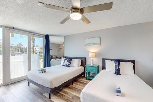 a bedroom with two beds and a ceiling fan at The Top of the Gulf #112 in Panama City Beach