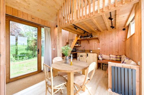 a dining room with a table in a tiny house at Les Cabanes Champêtres - Le Domaine des Trois Tilleuls in Villers-la-Ville