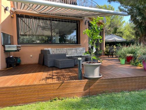 une terrasse en bois avec un canapé. dans l'établissement Maison Provençale de 130M jardin arboré, à Rognac