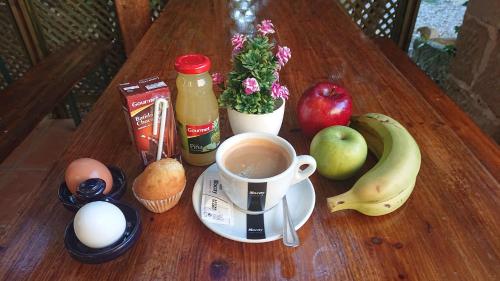 Una mesa con una taza de café y frutas y verduras. en Albergue Sansol - El oasis del camino francés - Exclusivo para peregrinos, en Sansol