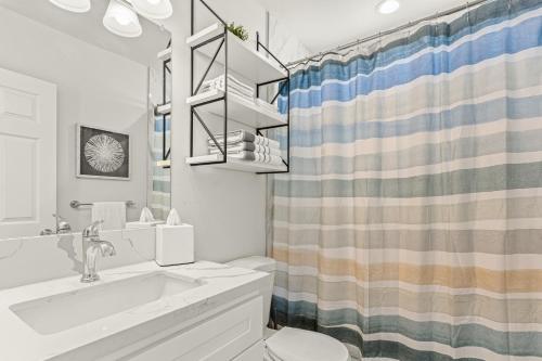 a bathroom with a sink and a shower curtain at Simi-valley Apartment By Pmi in Simi Valley