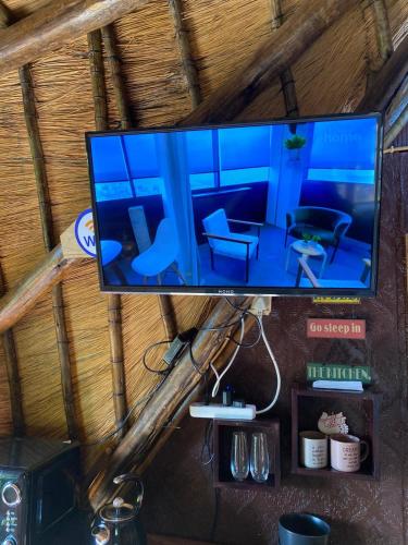a flat screen tv hanging on a wooden wall at Sweet Melody Tree House in Gaborone