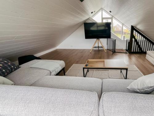 a living room with two couches and a flat screen tv at Kololo Cabin in Búrfell