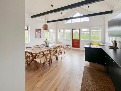 a kitchen and dining room with a table and chairs at Kololo Cabin in Búrfell