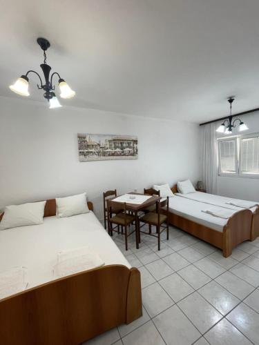 a room with two beds and a table and chairs at Apartments Sole Mar in Sutomore