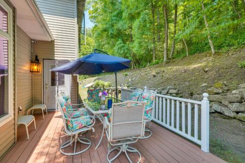 a porch with two chairs and an umbrella at Porch and Fire Pit Shawnee on Delaware Home! in East Stroudsburg