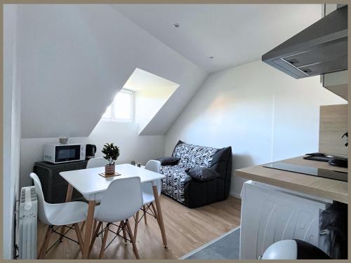 een kleine woonkamer met een tafel en een bank bij SQ'Appart-y in Saint-Quentin
