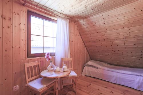 a room with a small table and a bed and a window at Mandala Domki in Bobolin