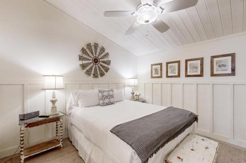 una camera da letto bianca con un letto e un ventilatore a soffitto di The Cottage a Temecula