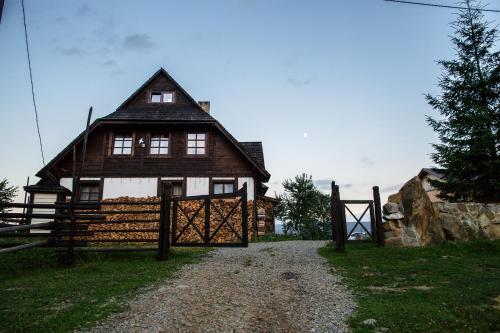 a wooden house with a gate in front of it at Blyzhche Neba in Yablunytsya