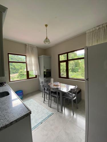 a kitchen and dining room with a table and chairs at Yomra İkisu Garden House in Yomra