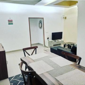 a living room with a table and a television at Logement paisible à Mpita in Pointe-Noire