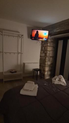 a room with a tv on the wall with towels at Il Campanile in Santa Maria del Molise