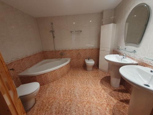 a bathroom with two sinks and a tub and a toilet at Apartamento para 6 personas en Alcalá de Xivert in Alcalá de Chivert