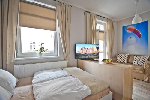 a bedroom with a bed and a television in it at Apartamenty Leszno in Leszno