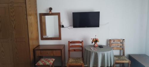 a room with a table and a mirror and a television at Kaiti Studios 1 in Koukounaries