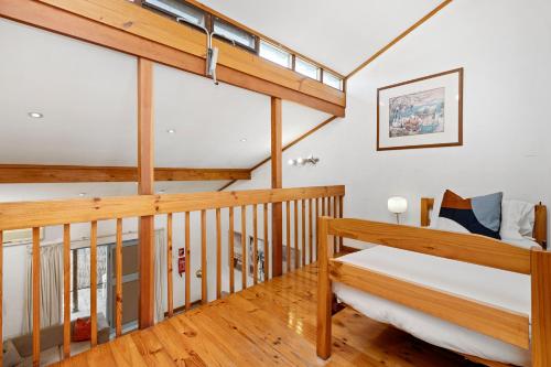 a loft bedroom with a bed and a staircase at 11 Cottesloe - steps from beach - sleeps 3 in Perth