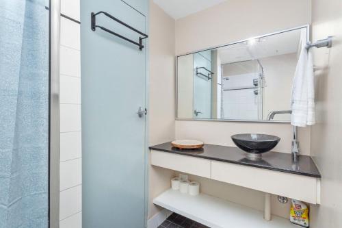 a bathroom with a sink and a mirror at 13 Cottesloe - steps from beach - sleeps 3 in Perth