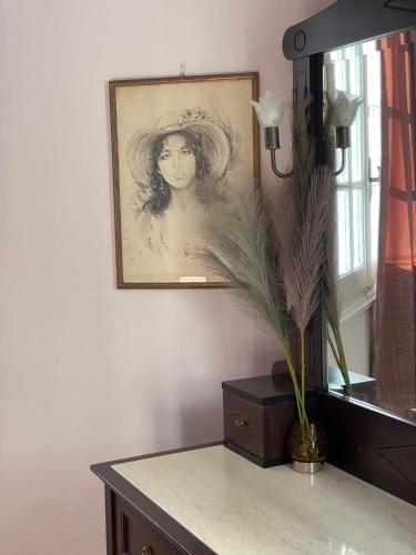 a drawing of a woman on a table with a vase at Palaiopolis house in Kanoni