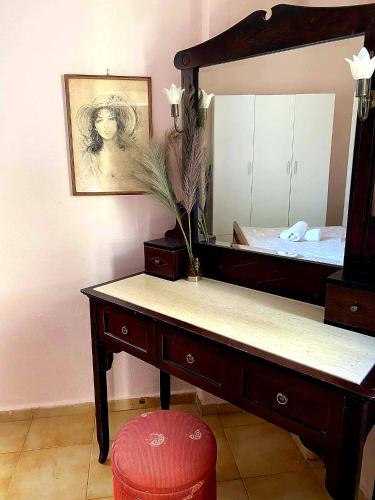 a dressing table with a mirror and a red stool at Palaiopolis house in Kanoni
