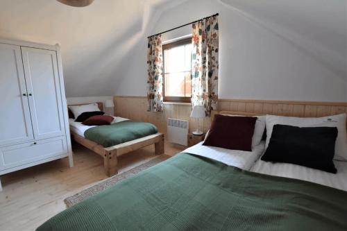 Borowy MłynにあるDomek na Kaszubach 3-2 - Ostoja Bukowoのベッド2台と窓のある寝室