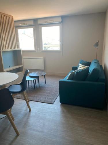 un salon avec un canapé bleu et une table dans l'établissement T2 cozy à 1km de Saint Charles, à Marseille