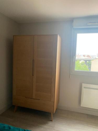 une armoire en bois dans une chambre avec fenêtre dans l'établissement T2 cozy à 1km de Saint Charles, à Marseille