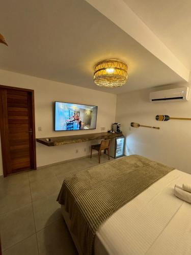 a bedroom with a bed and a flat screen tv at Pousada Amazing Jeri in Jericoacoara