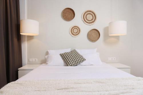 a bedroom with a bed with white sheets and pillows at Hotel Magdalena in Pefkohori