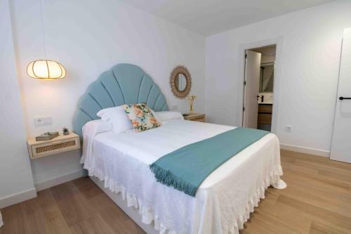 a bedroom with a large bed with a blue headboard at Artes Homes in San José