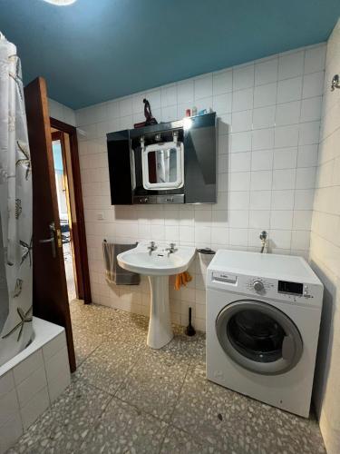 a bathroom with a washing machine and a sink at Casa de campo adosada in Viveiro