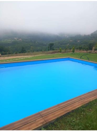 a blue swimming pool with a view of the mountains at Casa de Silvares in Celorico de Basto