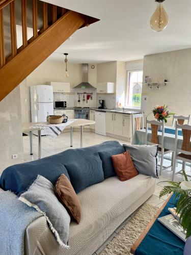 un salon avec un canapé bleu et une cuisine dans l'établissement La Pouardais, à Trégon