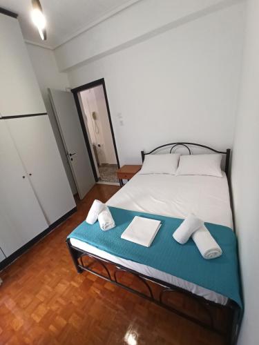 a bedroom with a bed with two towels on it at Olympus Terra Apartments No1 in Litochoro