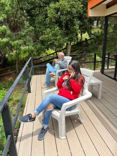 a woman sitting on a chair talking on a cell phone at El Cobijo in Chocontá