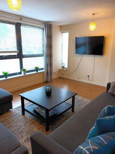 a living room with a couch and a coffee table at Fabulous 2 bed apt 10 mins from City Centre in Glasgow