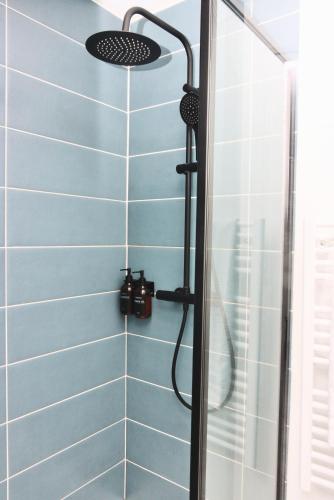 une salle de bain avec douche aux carreaux bleus dans l'établissement La Source - Spacieux T2 au coeur du village, à 5min des plages, à Saint-Méloir-des-Ondes