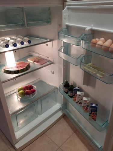 an open refrigerator with fruits and eggs in it at Sweet Nest Of Meteora in Kalabaka