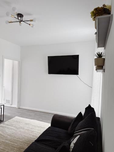 a living room with a couch and a flat screen tv at Ty Noah- Home In The Heart Of Pembrokeshire in Milford Haven