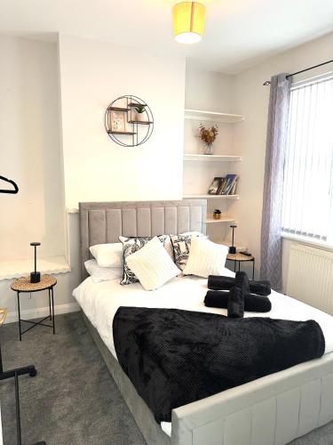 a bedroom with a large bed with black blankets and pillows at Ty Noah- Home In The Heart Of Pembrokeshire in Milford Haven