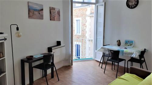 ein Wohnzimmer mit einem Tisch und Stühlen in einem Zimmer in der Unterkunft Studio vue mer 1r étage avec balcon in Les Sables-dʼOlonne