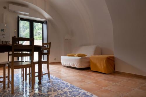 a dining room with a table and a bed at PALAZZO PELLEGRINO vietri in Vietri sul Mare