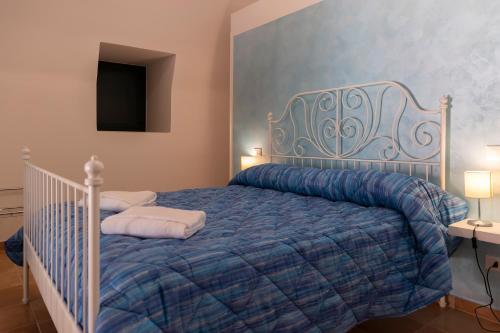 a bedroom with a bed with a blue comforter at PALAZZO PELLEGRINO vietri in Vietri sul Mare