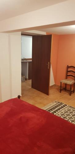 a bedroom with a bed and a chair and a door at Casa Gama in Ribeira da Janela