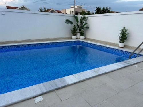 una piscina sul lato di un muro bianco di ORA apartments a Donji Štoj